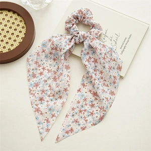 Detailed view of pink floral ribbon scrunchie with delicate chiffon fabric and patterns