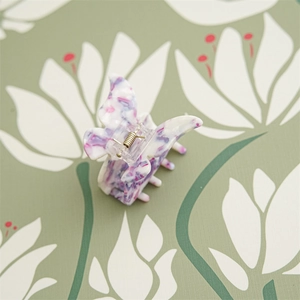 Détail d'une pince à cheveux papillon avec motif marbré violet et mécanisme à ressort
