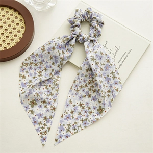 Detail of light blue floral scrunchie with long ribbons on a decorative background