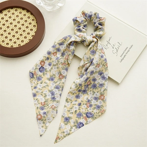 Detailed view of floral scrunchie with long ribbons on a white background decor