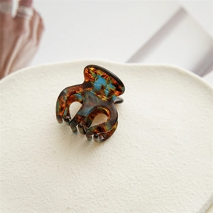 Détail de la pince à cheveux motif écaille de tortue avec des touches de bleu sarcelle