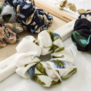 Close-up of floral print scrunchies in chiffon fabric showing high elasticity and texture