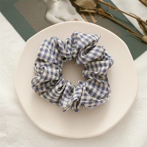 Detail shot of a blue and white checkered fabric scrunchie on a decorative white plate
