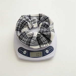 Detailed view showing the 10.9g lightweight black and white checkered scrunchie on a scale