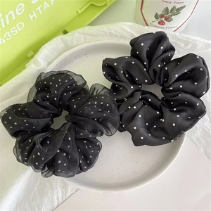 Dettaglio del set di elastici neri a pois in raso e organza trasparente