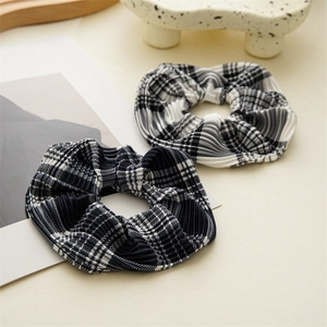 Detailed view of pleated checkered scrunchies in classic black, white and navy blue patterns