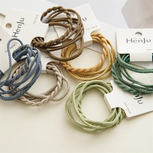 Set of colorful braided elastic hair bands in assorted earthy tones on white display cards