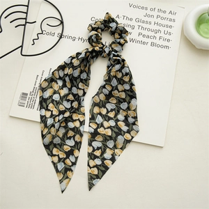 Vue détaillée du chouchou floral noir avec motifs de tulipes et longs rubans