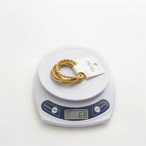 Detail shot of durable braided hair elastics in champagne gold on a digital scale
