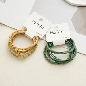Detail of high-elasticity braided hair ties in ginger and dark green on display cards