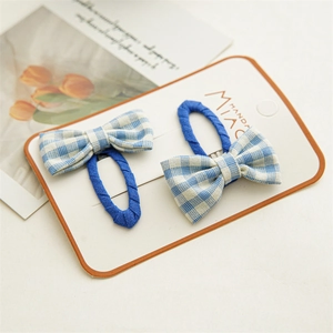 Detail of blue and white plaid bow hair clips set on a decorative display card