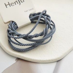 Close-up of gray-blue twisted elastic hair bands on a white display card
