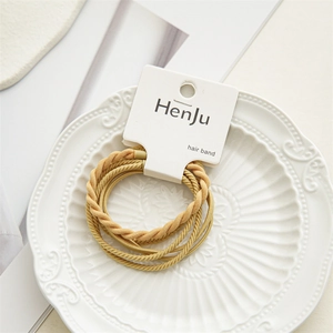 Close-up of ginger yellow high-elastic braided hair band set on white card packaging