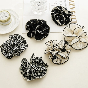 Detail of six-piece black and white fabric scrunchie set with contrast stitched edges