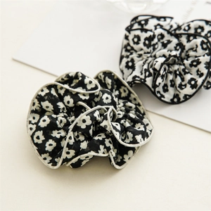 Close-up of floral scrunchies with pleated fabric and contrast binding in black and white