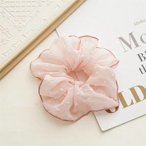 Detail eines rosa Chiffon-Haargummis mit weißen Beflockungspunkten und feiner Randnaht