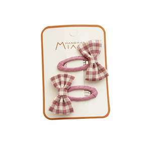Set of two handmade plaid bow hair clips in pink fabric with classic grid pattern