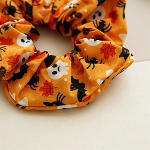 Détail d'un chouchou d'Halloween orange avec motifs fantômes et chauves-souris imprimés