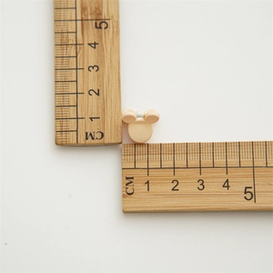 Macro detail of mini beige cartoon hair claw showing 1.5cm size measurement on ruler