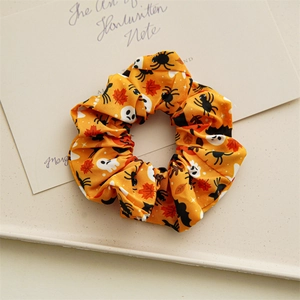 Détail du chouchou orange d'Halloween avec motifs de fantômes et d'araignées