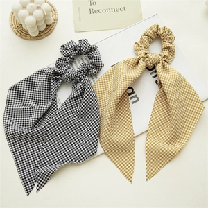Detail of plaid gingham scrunchies with ribbons in black and yellow on white magazine