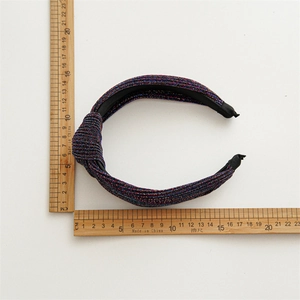 Flat lay of woven knot headband with rulers showing 14cm width and sparkling texture