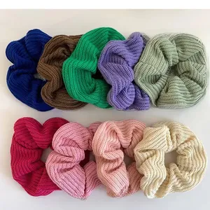 Flat lay of nine colorful knitted scrunchies with textured ribbing on white background