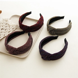 Detail of four assorted metallic knotted headbands with sparkling braided fabric texture