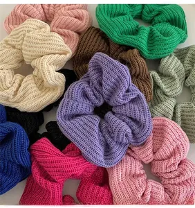 Flat lay of colorful knitted oversized scrunchies showing various solid colors and ribbed texture