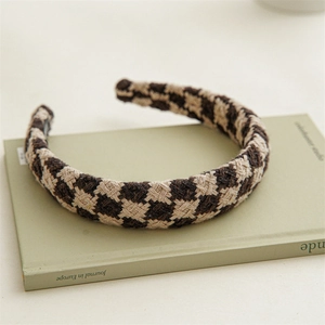 Detailaufnahme des braun karierten Strickstirnbands mit dicker Textur und Gewebedetails