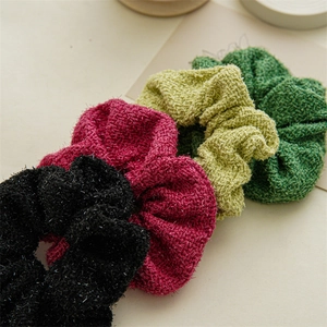 Détail de chouchous en tweed avec fil métallique en noir, rose et nuances de vert
