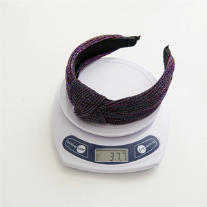 Close-up of knotted fabric headband weighing 37.7g on electronic scale for weight check