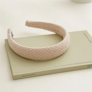 Detail eines rosa Hahnentritt-Haarreifens mit weicher Tweed-Textur und hohem Design