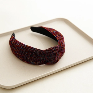Close-up of pink glitter knotted headband with shimmering metallic fabric texture