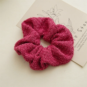 Gros plan sur un chouchou tricoté rose rouge avec fil d'argent brillant et texture