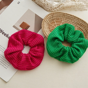 Close-up of pink and green knitted hair scrunchies with soft ribbed texture