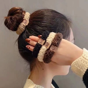 Détail de trois chouchous en peluche avec étiquettes sourire en couleurs neutres