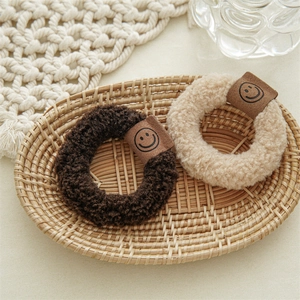 Chouchous en peluche marron et beige avec étiquettes minimalistes en cuir à smiley