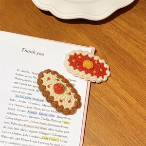 Détail de barrettes à cheveux crochetées main fraise et fleur sur un livre ancien