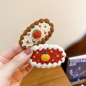 Détail de barrettes à cheveux faites main au crochet, fraise et orange, texture tricot