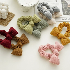 Detailed view of knitted bow hair ties in various Morandi colors with textured fabric