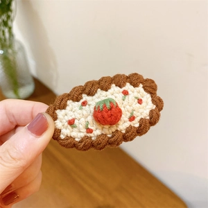 Détail de la pince à cheveux au crochet faite main avec petite fraise brodée