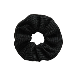 Chunky black knitted scrunchie with soft wool texture for hair styling in minimalist style