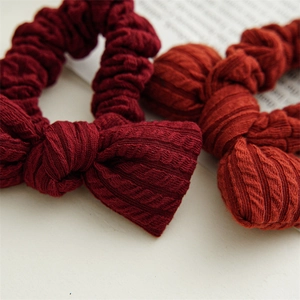 Macro shot of knitted hair scrunchies with bow details and cable knit texture