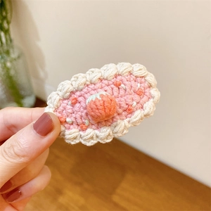 Détail de la barrette à cheveux rose crochetée à la main avec une fraise et bords ondulés