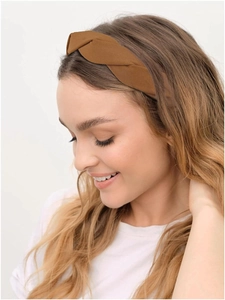 Detail of elegant caramel twisted headband with twill fabric texture on model's hair