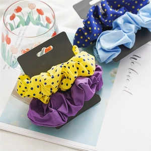 Detail of fabric scrunchies set with polka dots and solid colors on display card