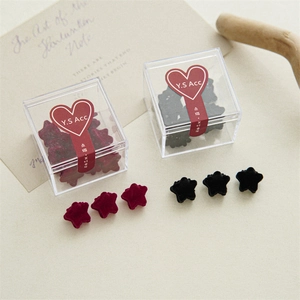 Mini velvet star hair clips in burgundy and black within a clear acrylic box packaging