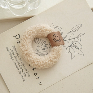 Gros plan d'un chouchou en peluche beige avec patch en cuir souriant sur carte déco
