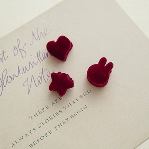 Detailed macro view of burgundy velvet mini hair clips in heart, star and rabbit shapes